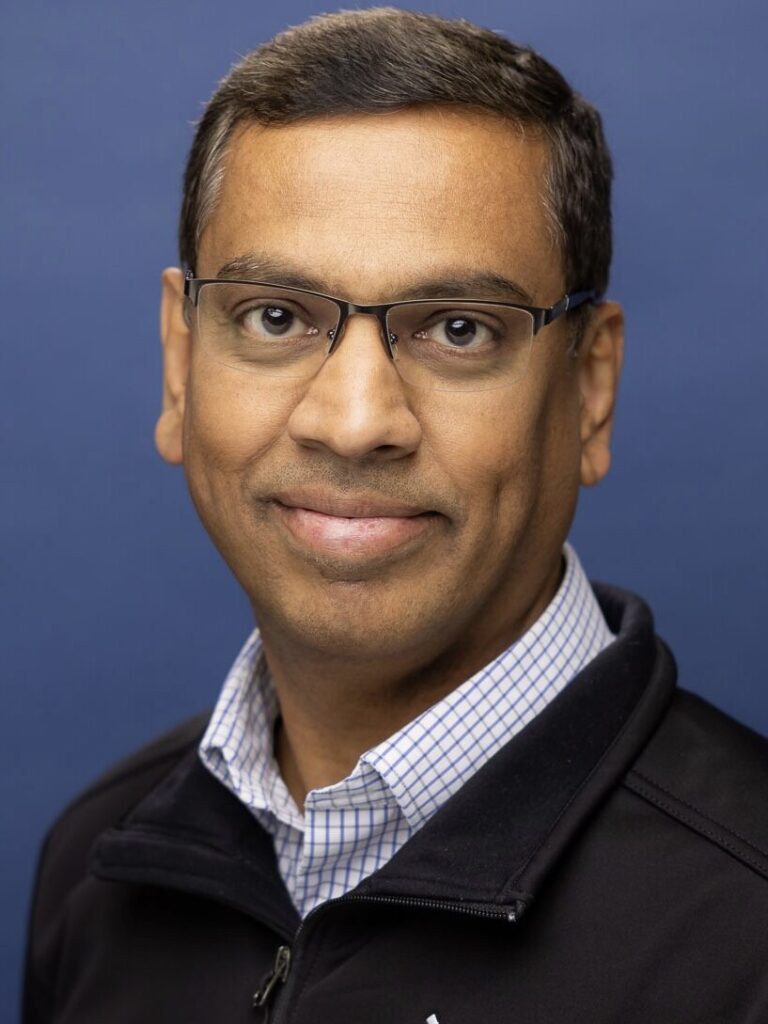 A man with glasses and a black jacket