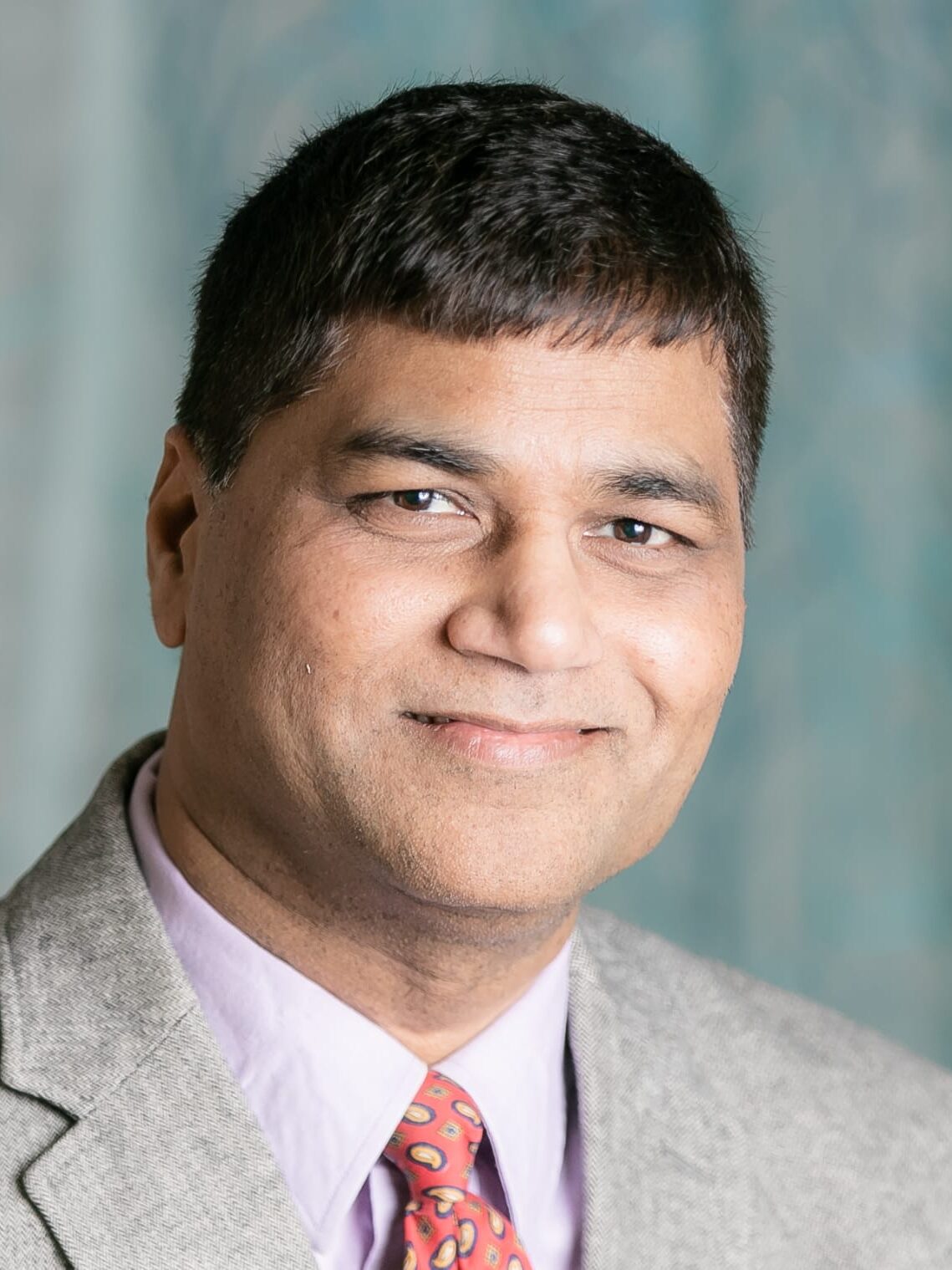 A man with a mustache wearing a suit and tie.