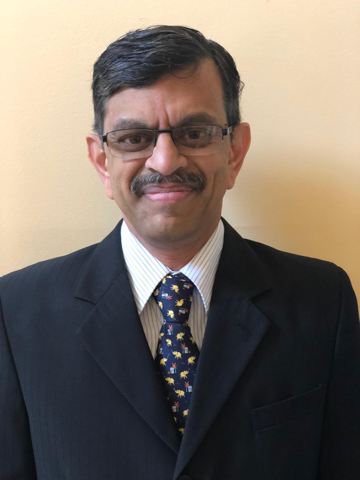 A man with a mustache wearing a suit and tie.