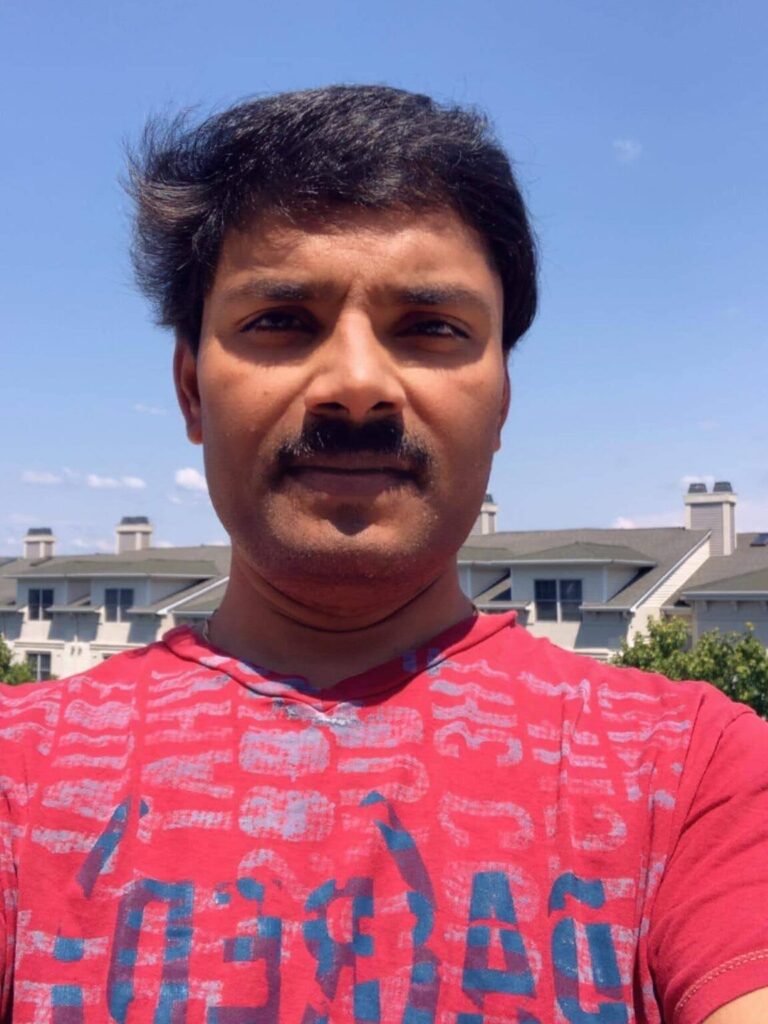 A man with a mustache wearing a red shirt.